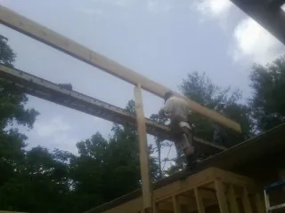 Carpenter setting a ridge beam over a new addition frame — Ice Dam Removal by Roofing Brothers in San Geronimo