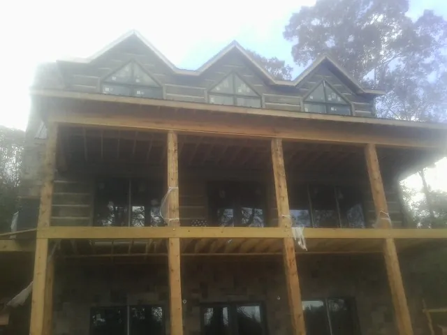 Dormers and porch framing on a large log home under construction — Roof Coating work by our crew in San Geronimo