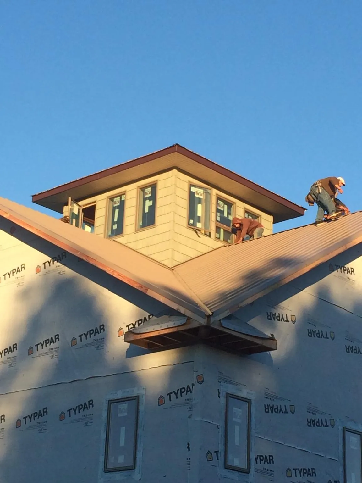 Roofers working around a rooftop cupola on a new metal roof at sunset — Roof Waterproofing in San Geronimo by Roofing Brothers